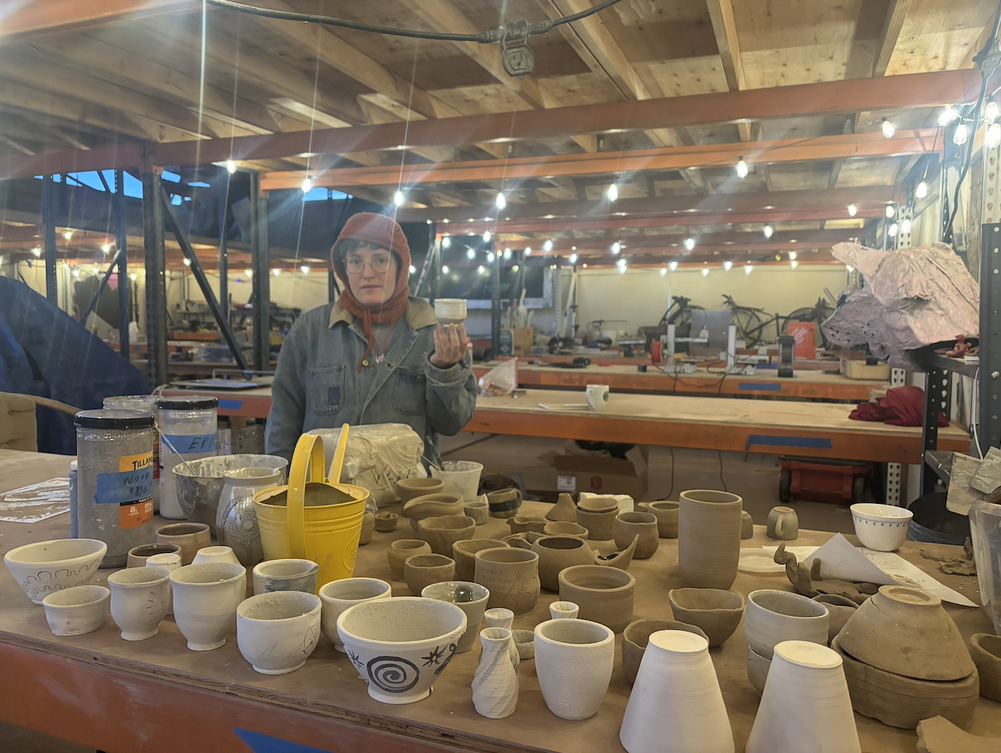 Resident showing off greenware pottery in the ceramics studio