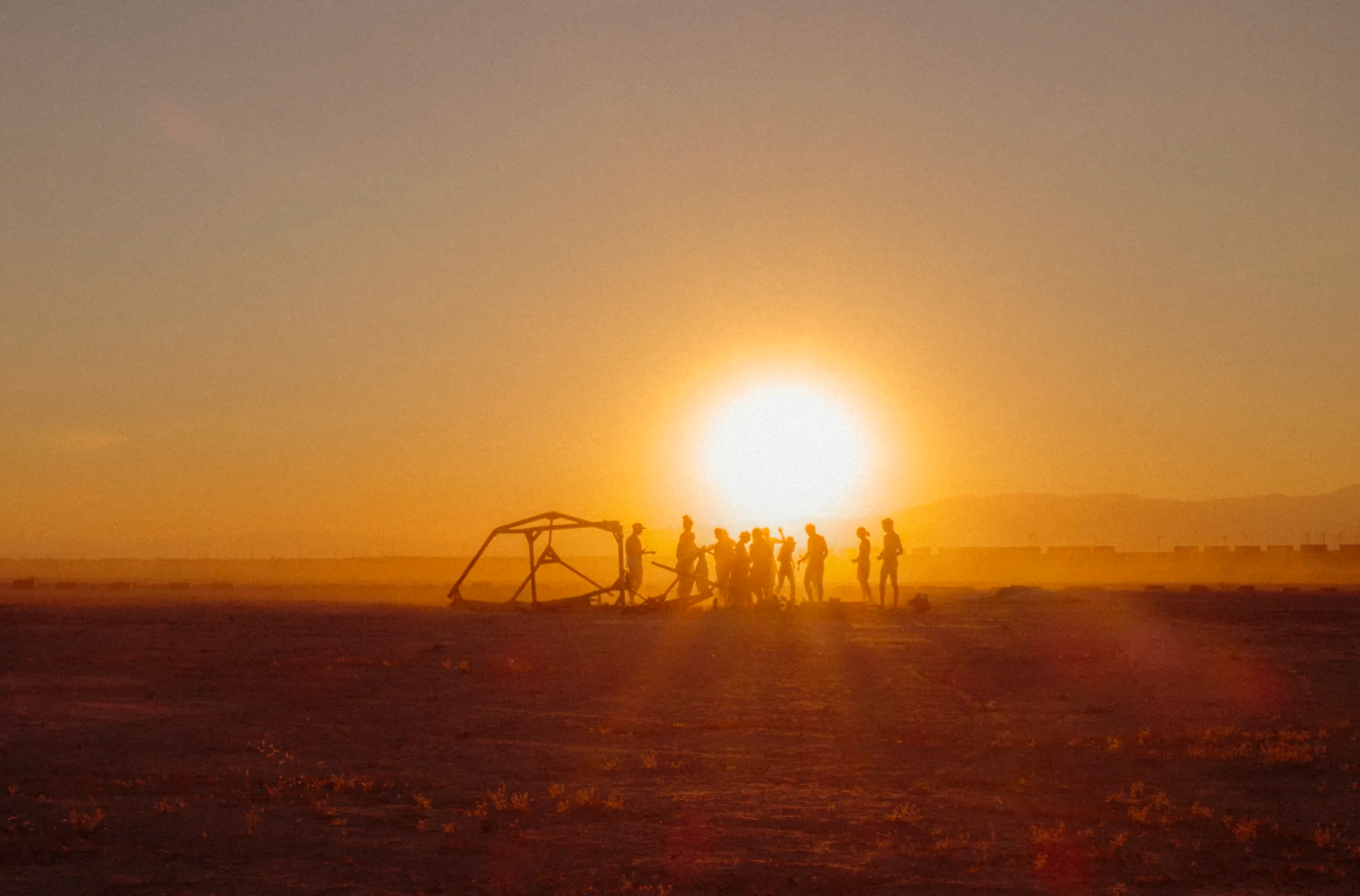Group silhouetted against a desert sunset