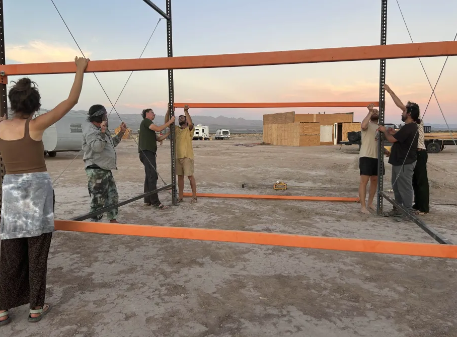 Residents raising the workshop frame at dusk