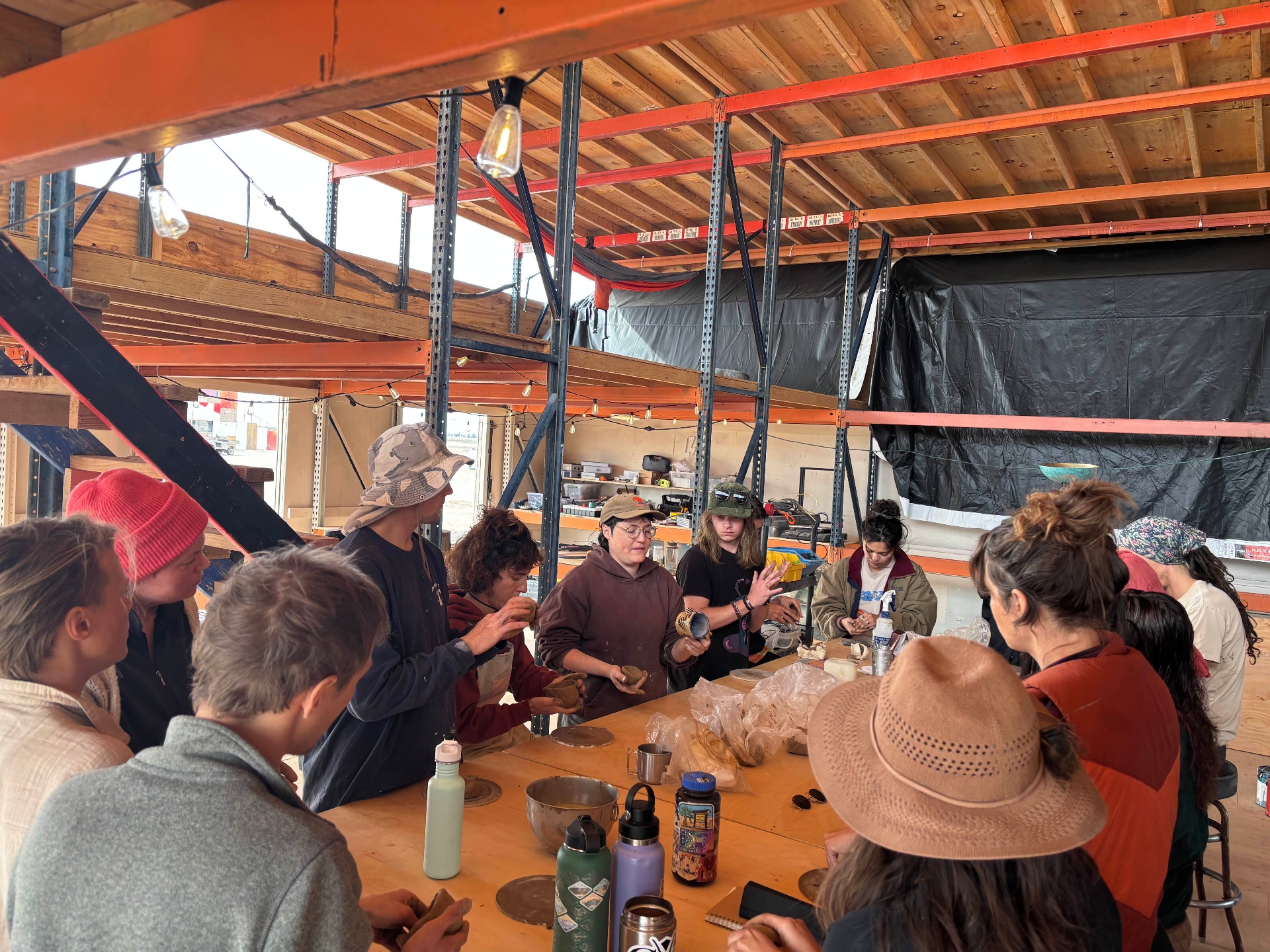 Residents gathered around a workshop table shaping clay together